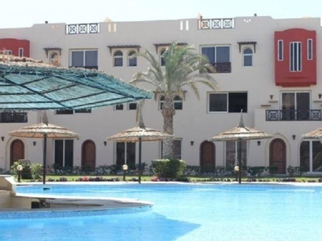 Pool area with apartment in the backdrop