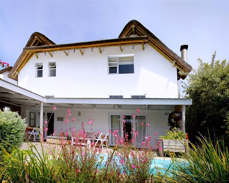North facing side of the house with covered deck, pool and braai