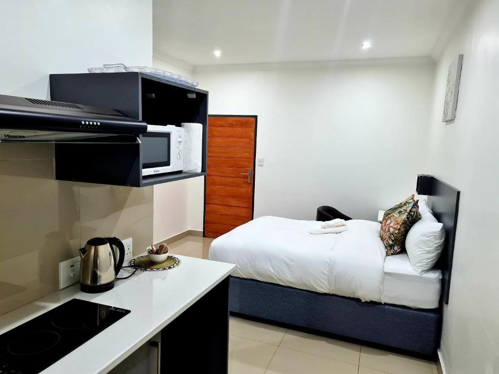 Room with double bed, private bathroom and kitchen